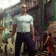 Agent 47 stands in an alleyway while wearing sunglasses.
